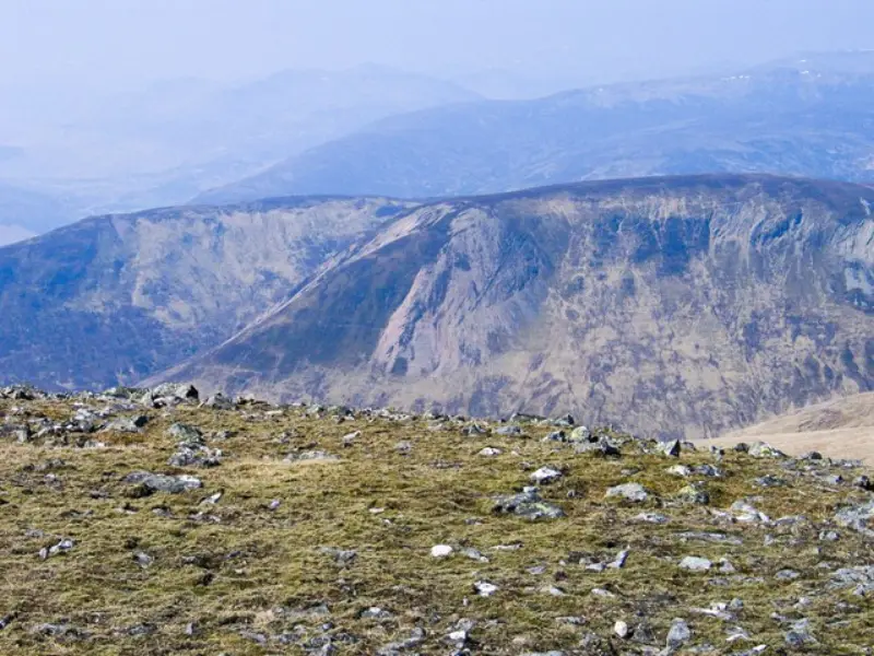 NN6350 : Grassed ground with studded rocks at summit of Carn Gorm